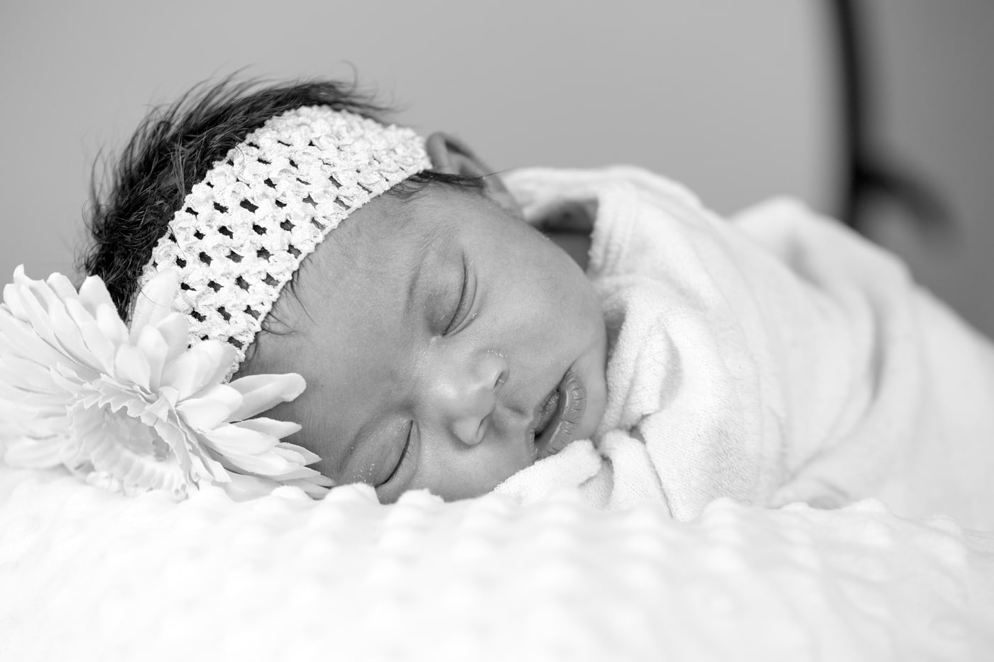 Newborn portrait with quiet black-and-white detail. Photograph by Samuel Mfinanga for Mfinanga Photography + Motion.