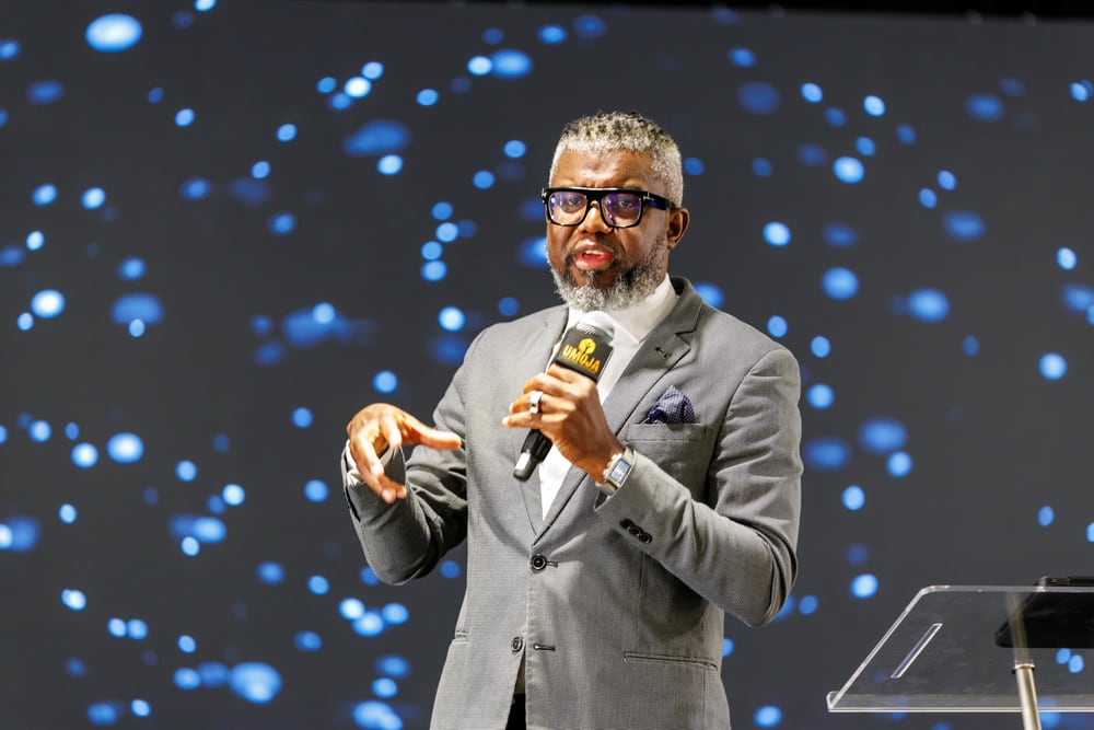 Keynote speaker with polished stage backdrop.
