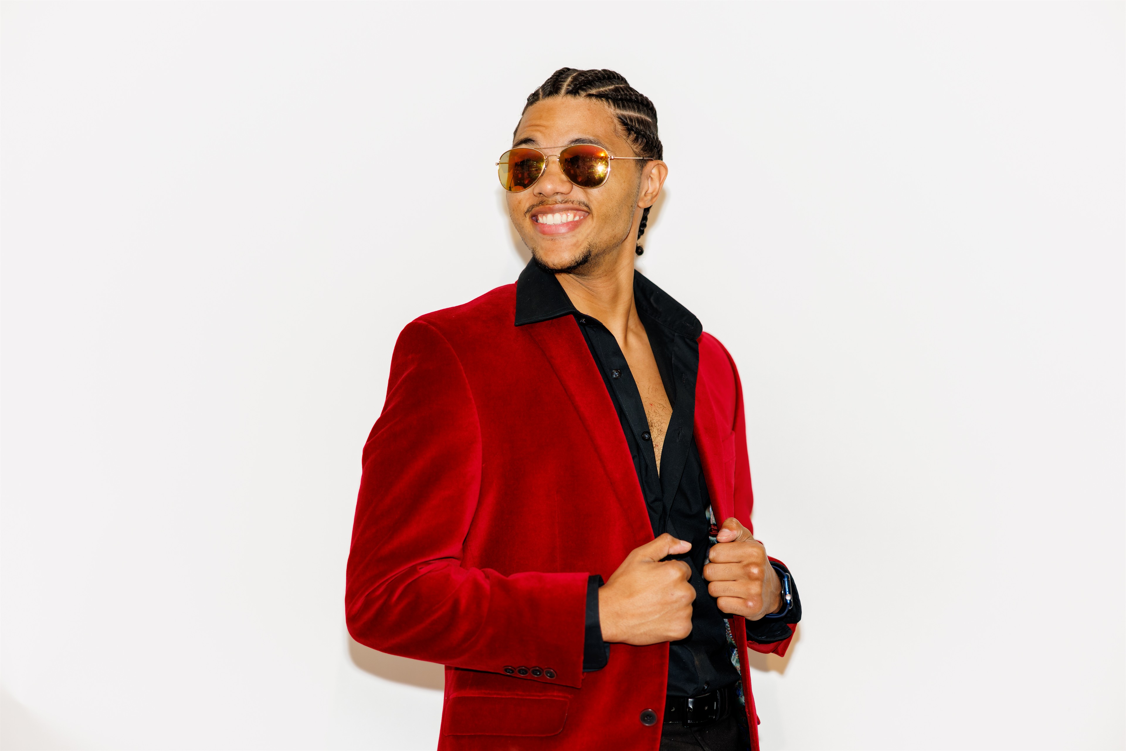 Personal-brand portrait in red blazer on clean white. Photograph by Samuel Mfinanga for Mfinanga Photography + Motion.