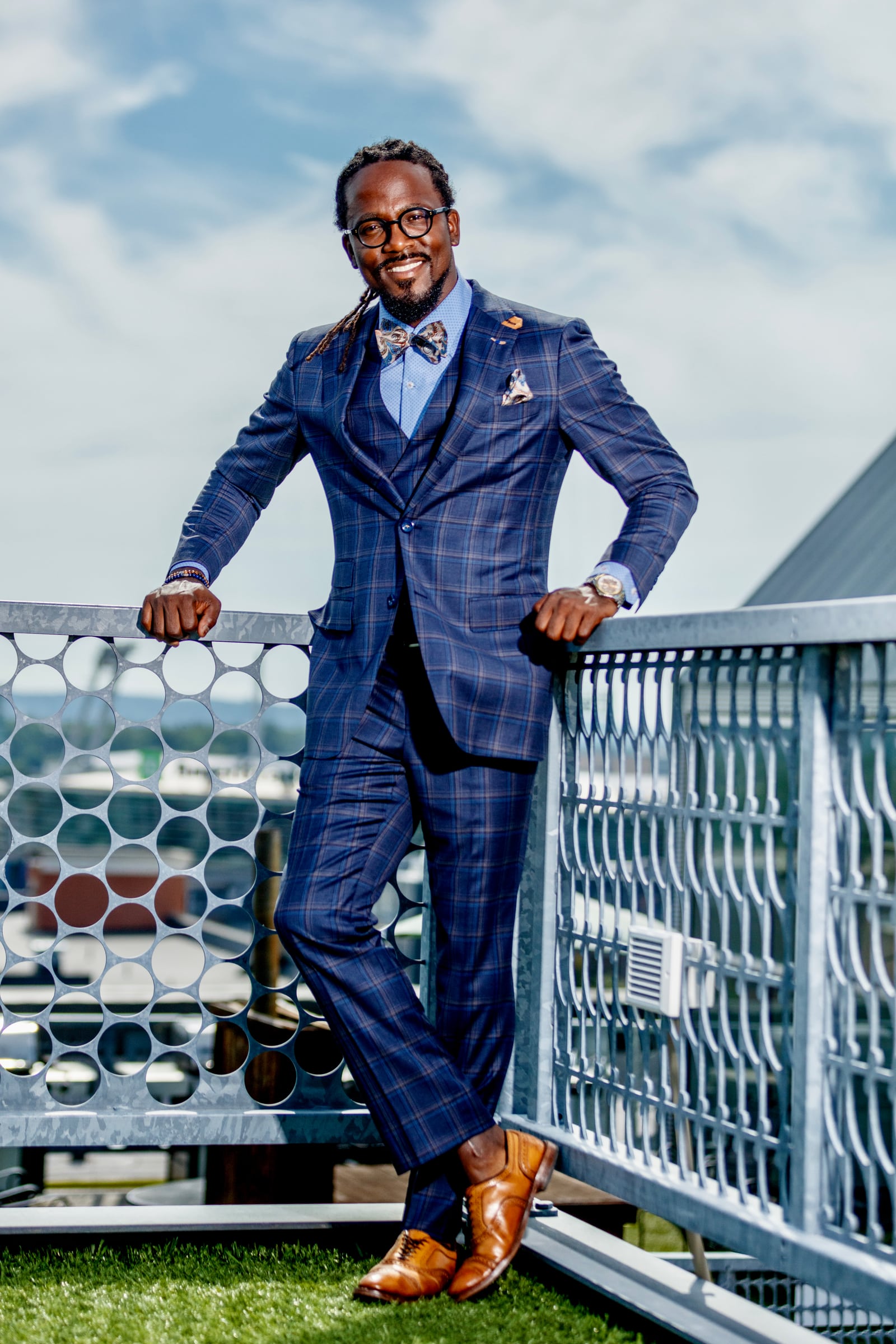 Executive blue suit above skyline, aspirational portrait. Photograph by Samuel Mfinanga for Mfinanga Photography + Motion.