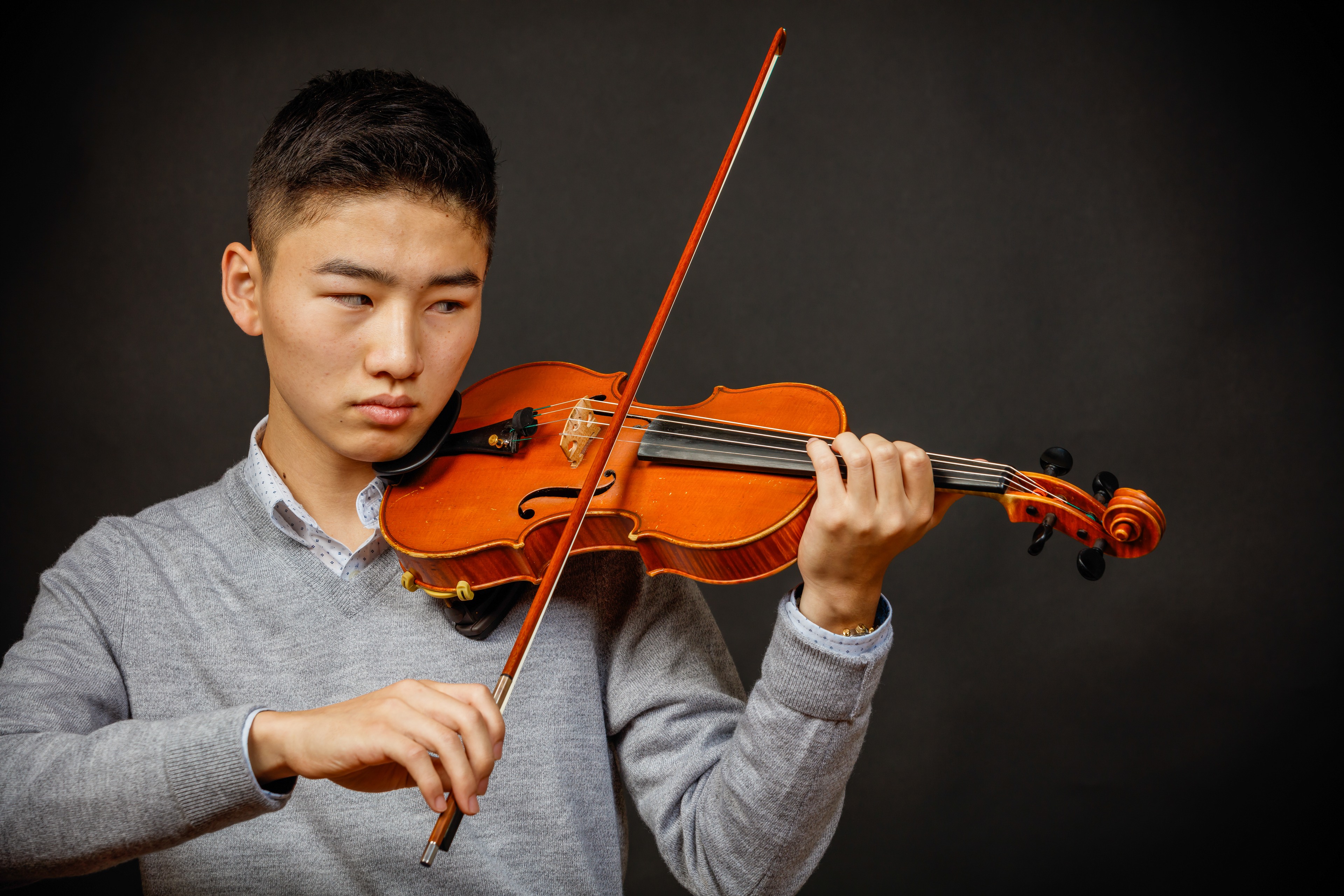 Senior musician portrait with violin and dramatic studio light. Photograph by Samuel Mfinanga for Mfinanga Photography + Motion.