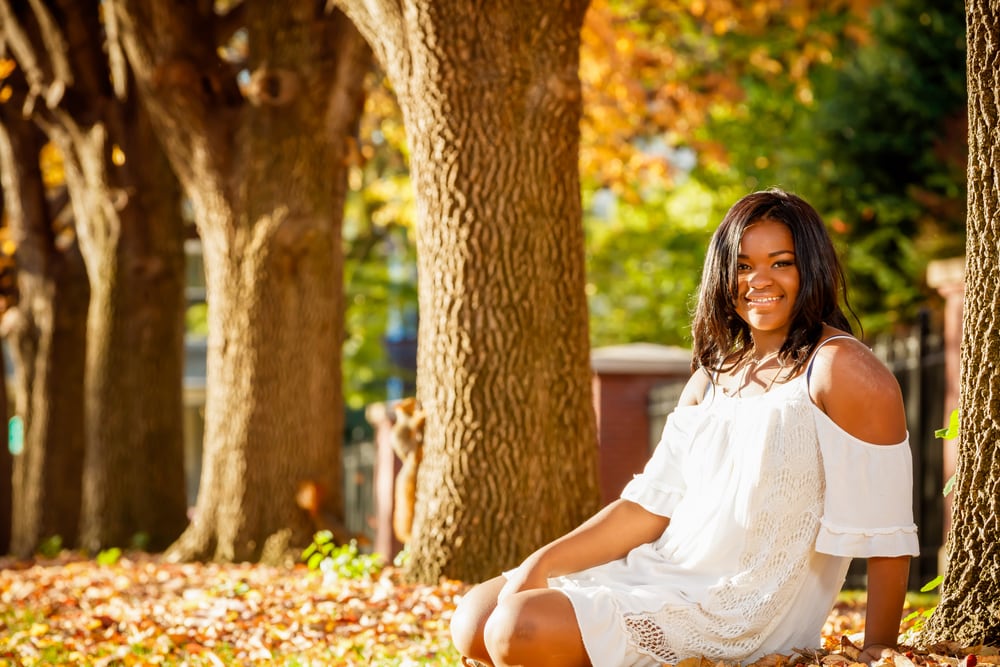 Bright outdoor senior portrait in white dress.