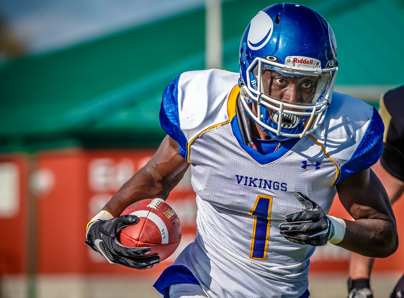 Football Vikings #1 running with ball, strong action. Photograph by Samuel Mfinanga for Mfinanga Photography + Motion.